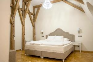 a bedroom with a bed in a room with wooden beams at Pałac Popielów w Kurozwękach- pokoje w Pałacu in Kurozwęki