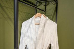 a white robe is hanging on a hanger at The Leiston, 1 Valley Road in Leiston +18 photos