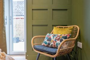a wicker chair with a pillow in a room at The Leiston, 1 Valley Road in Leiston