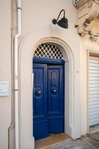 a blue door on the side of a building at Traditional Maltese 2-Bedroom Home with Private Hot Tub - Steps Away from Valletta in Il-Furjana