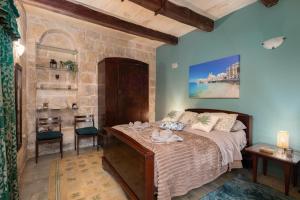 a bedroom with a bed with shoes on it at Traditional Maltese 2-Bedroom Home with Private Hot Tub - Steps Away from Valletta in Il-Furjana