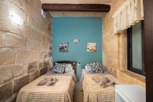 a room with four beds with stuffed animals on them at Traditional Maltese 2-Bedroom Home with Private Hot Tub - Steps Away from Valletta in Il-Furjana