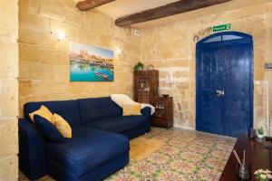 a living room with a blue couch and a blue door at Traditional Maltese 2-Bedroom Home with Private Hot Tub - Steps Away from Valletta in Il-Furjana +44 photos