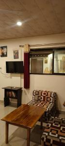 a living room with a wooden table and a couch at Bonsaiyog in Chapora