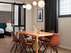 a dining room with a wooden table and chairs at YAYS Paris Issy by Numa in Issy-les-Moulineaux
