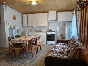 a kitchen with a table and chairs in a room at Levendula Vendégház in Ács