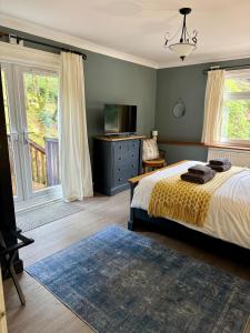 a bedroom with a bed and a dresser and a television at Lochwood House & The Wild Spa in Lochgoilhead +91 photos