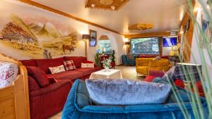 a living room with red couches and a table at L'Hermine Blanche in Morzine
