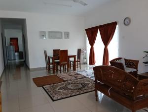 a living room with a couch and a table and chairs at Seri Cempaka Homestay in Kluang