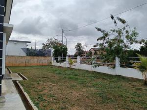 a backyard with a white fence and a yard at Seri Cempaka Homestay in Kluang