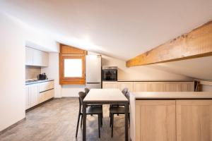 a kitchen with a table and chairs in a room at Chesa Sarvit in Celerina