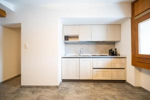 a kitchen with white cabinets and a sink at Chesa Sarvit in Celerina +34 photos