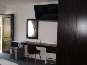 a room with a desk with a chair and a mirror at La Coscello Guest House in Edenvale