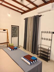 a room with a bed with towels on it at bluemoonhiriketiya in Dickwella