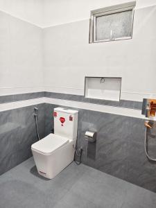 a bathroom with a white toilet in a room at bluemoonhiriketiya in Dickwella