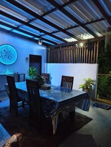 a dining room table with chairs and a blue ceiling at bluemoonhiriketiya in Dickwella
