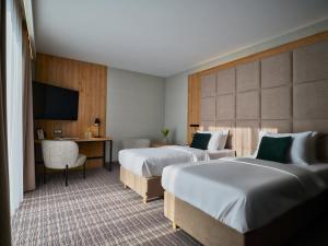 a hotel room with two beds and a television at Hotel Verde City in Koszalin +150 photos