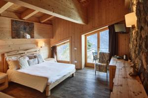 a bedroom with a bed in a wooden cabin at Chalet Morel 1586 Hotel & Spa in Limone Piemonte +123 photos