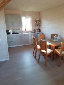a kitchen with a table and chairs in a room at Dar Morza Domki Letniskowe in Gąski