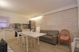 a kitchen and living room with a table and a couch at Dimora Centro Storico in Sirolo