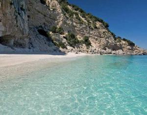 a beach with clear water and a mountain at Dimora Centro Storico in Sirolo