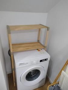 a washing machine with a wooden shelf on top of it at charnecas house in Gaula