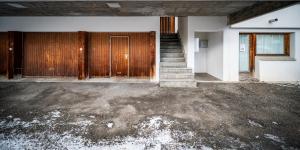 an empty room with a staircase and a wooden door at Chesa Sarvit in Celerina