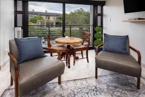 a dining room with a table and chairs and a window at Topiary Lux Studio 16! in Herolds Bay