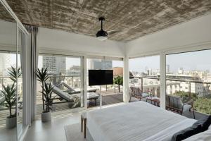 a bedroom with a bed and a balcony with a tv at Mr Rothschild By TLV2GO in Tel Aviv