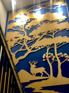 a blue wall with a deer and trees on it at Bless Red Hotels in Sintang