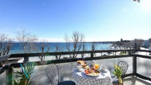 a table with a plate of food on a balcony at Desenzanoloft Garda Golden Sunrise official partner Homes and Villas By Marriott Bonvoy in Desenzano del Garda