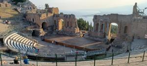 an amphitheater in a castle with people walking around at Rusina in Santa Venerina