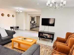 a living room with two couches and a tv at Thetsane Ridge in Maseru
