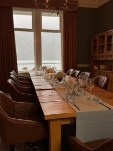 a long table in a room with chairs and a large window at Lochwood House & The Wild Spa in Lochgoilhead