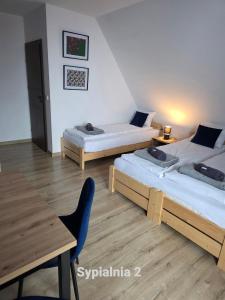 two beds in a room with a table and a dining table at Dom na Ubocy in Groń