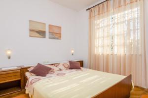 a bedroom with a bed and a large window at Holiday Apartment Maria in Orebić
