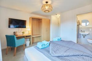 a bedroom with a bed and a desk and a chair at Haus Antina - App 2 in Borkum