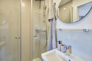 a bathroom with a shower and a sink and a mirror at Haus Antina - App 2 in Borkum +11 photos