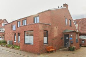 a red brick building with a bench in front of it at Haus Antina - App 2 in Borkum