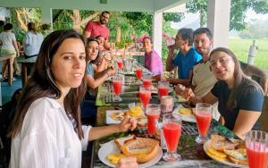 a group of people sitting at a table eating food at Thisara Guest House in Polonnaruwa