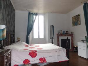 a bedroom with a bed with red flowers on it at Mas cantecou in Mosset