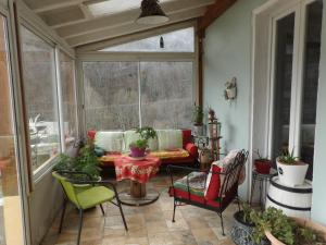 a screened in porch with a couch and chairs at Mas cantecou in Mosset