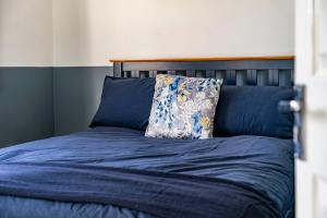 a blue bed with a pillow on top of it at Comfy 3 Bed House in Northampton