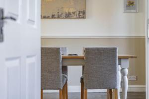 a dining room table with two chairs and a table at Comfy 3 Bed House in Northampton