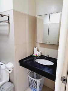 a bathroom with a sink and a toilet and a mirror at Coast Residences Roxas Boulevard Manila in Manila +4 photos