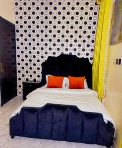 a bed with two orange pillows in a bedroom at Msb LUXURY HOME in Lekki