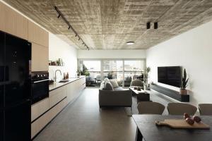 a kitchen and living room with a couch and a table at Mr Rothschild By TLV2GO in Tel Aviv +24 photos