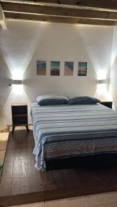 a bedroom with a bed with two lights on it at Quinta Di Crivelli in Praia do Rosa