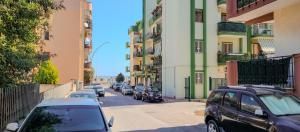 a row of cars parked on a street next to buildings at Dimora Il Roseto in Trani