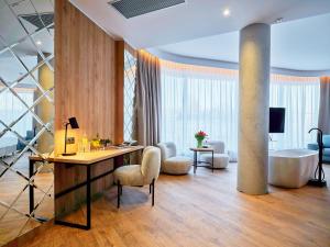 a lobby with a desk and a tub in a room at Hotel Verde City in Koszalin